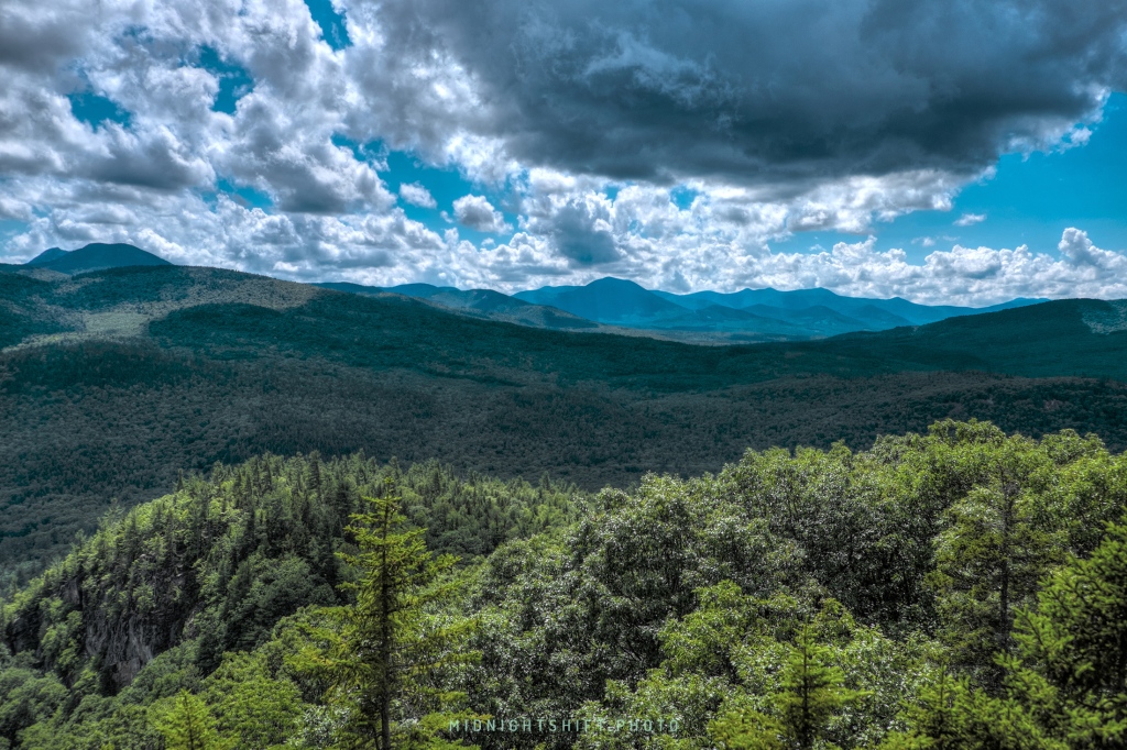 A looming rain cloud sits above the boulder loop trail in the White Mountains of New Hampshire