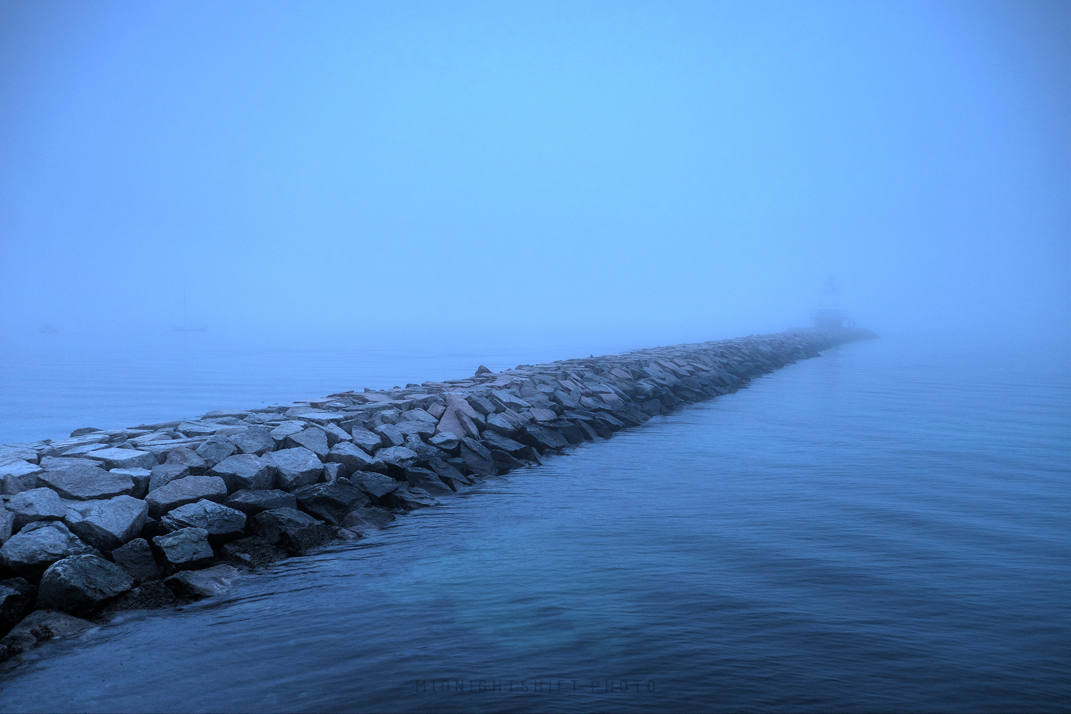 The spring point ledge lighthouse in South Portland, Maine sits in the dense fog.